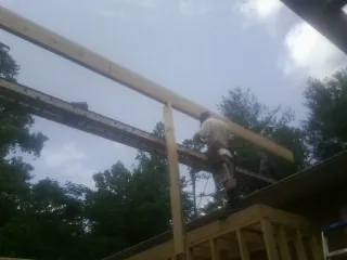 Carpenter setting a ridge beam over a new addition frame — Ice Dam Removal by Roofing Brothers in Champion