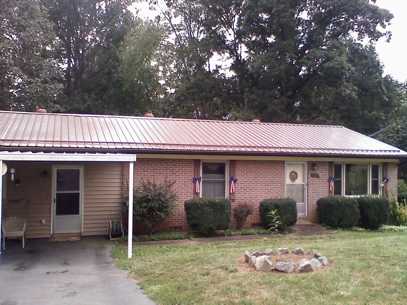 Bronze metal roof and carport on a brick ranch home in Champion